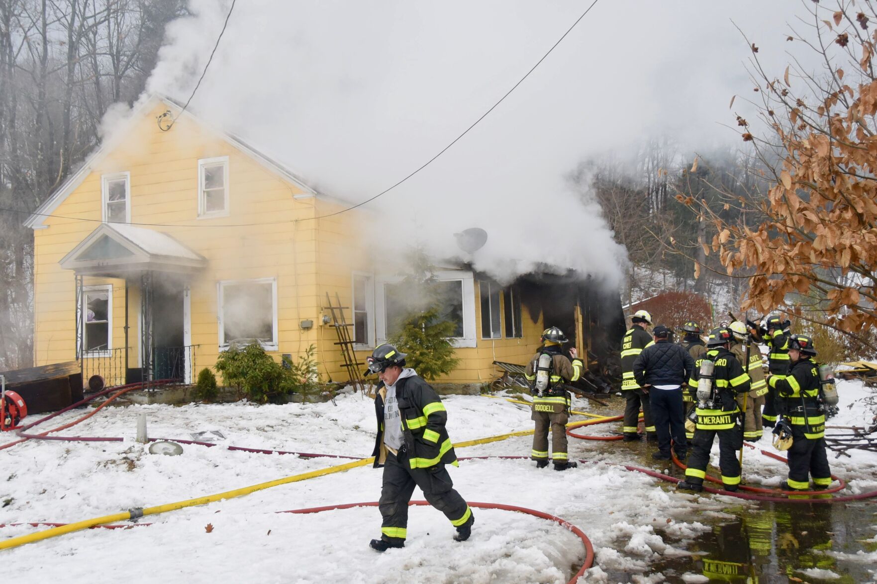 Firefighters work outside burning home